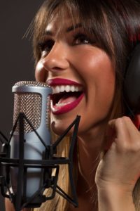 Happy Woman Singer In Front Of The Microphone