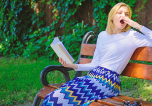 woman yawning with book