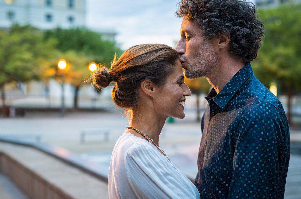 man kissing woman's forehead romance